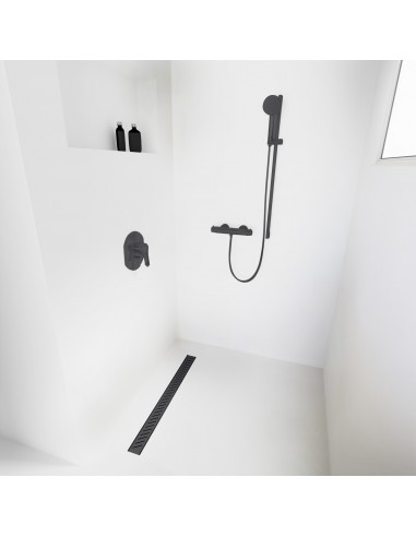 Open inloopdouche, omgeven door lichtgekleurde microcementvloer en -wanden, met armaturen in Black