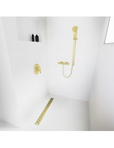 Open inloopdouche, omgeven door lichtgekleurde microcementvloer en -wanden, met armaturen in Gold