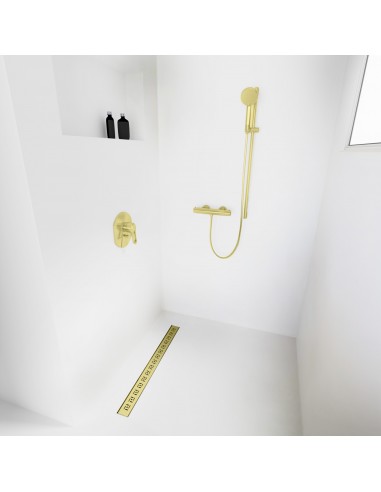 Open inloopdouche, omgeven door lichtgekleurde microcementvloer en -wanden, met armaturen in Gold
