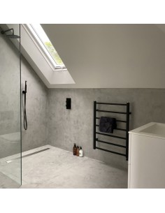 Douchegedeelte gemaakt van microcement in een industriële look met lineaire goot en armaturen in Brass