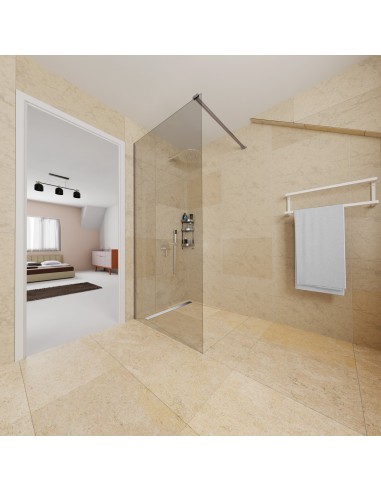 Open badkamer met regendouche, kalkstenen tegels en modern doucheglas met slaapkamer op de achtergrond